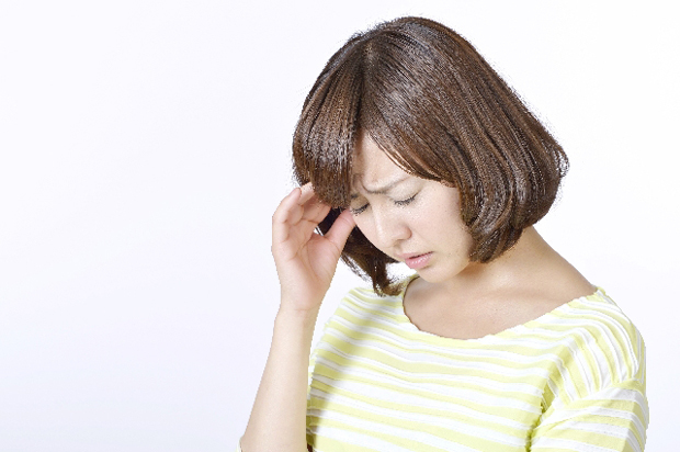 イメージ　頭痛で苦しんでいる女性